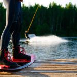 men’s feet on a wakeboard on forest landscape